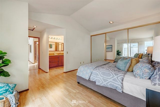 a bedroom with a large bed and wooden floor