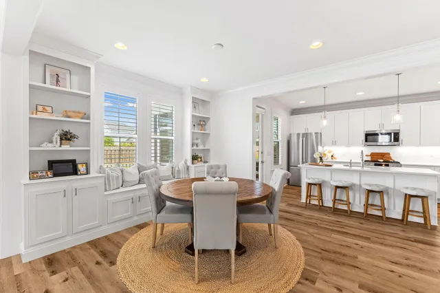 a kitchen with stainless steel appliances a refrigerator a sink dishwasher a stove and white cabinets with wooden floor