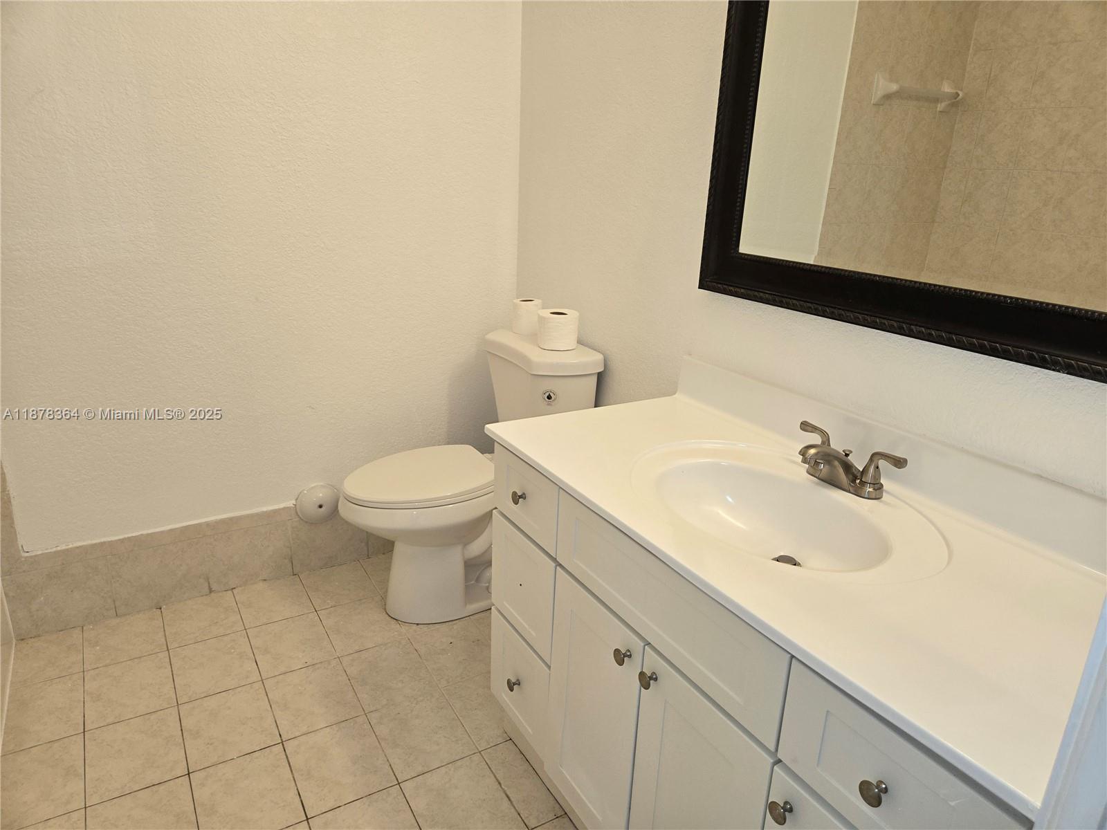 2903 Southeast 17th Avenue, Unit 111 Homestead, FL 33035 - Photo 12 of 15 a bathroom with a sink a toilet and mirror