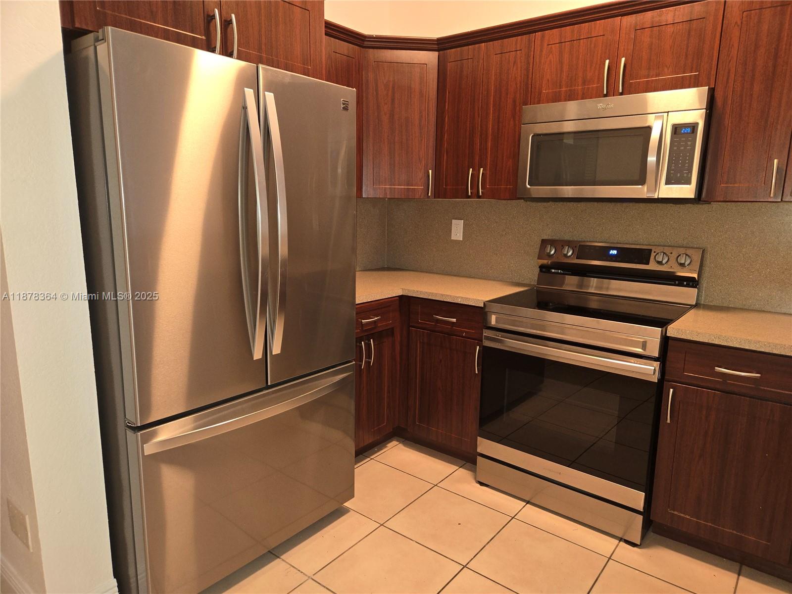2903 Southeast 17th Avenue, Unit 111 Homestead, FL 33035 - Photo 8 of 15 a kitchen with stainless steel appliances granite countertop a refrigerator and a microwave