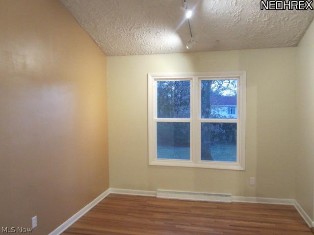 Formal dining room with vaulted ceiling & hard wood floor.