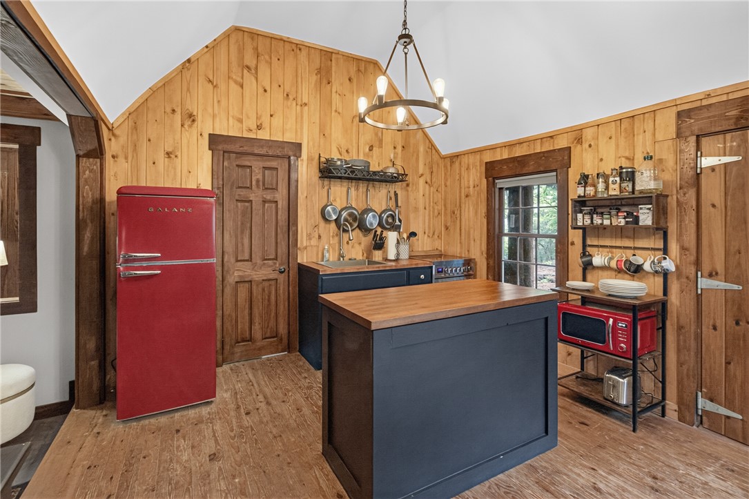 130 Maggie Rufus Lane Westminster, SC 29693 - Photo 10 of 50 A charming rustic kitchen features warm wood paneling and a striking red refrigerator.