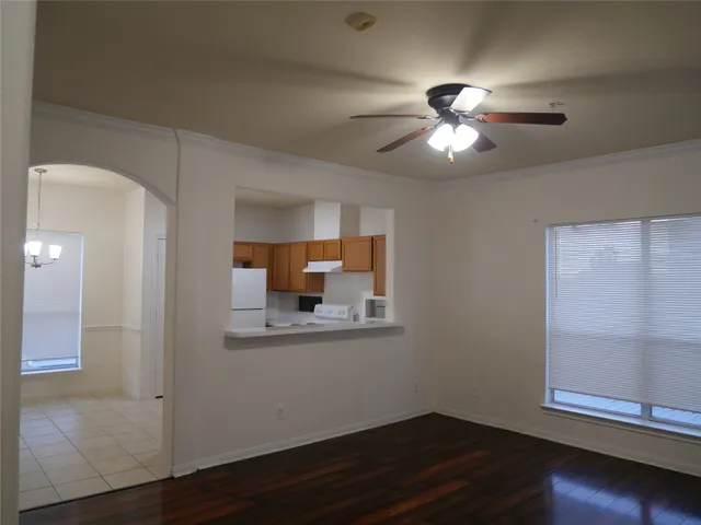 a view of a livingroom with wooden floor and a ceiling fan