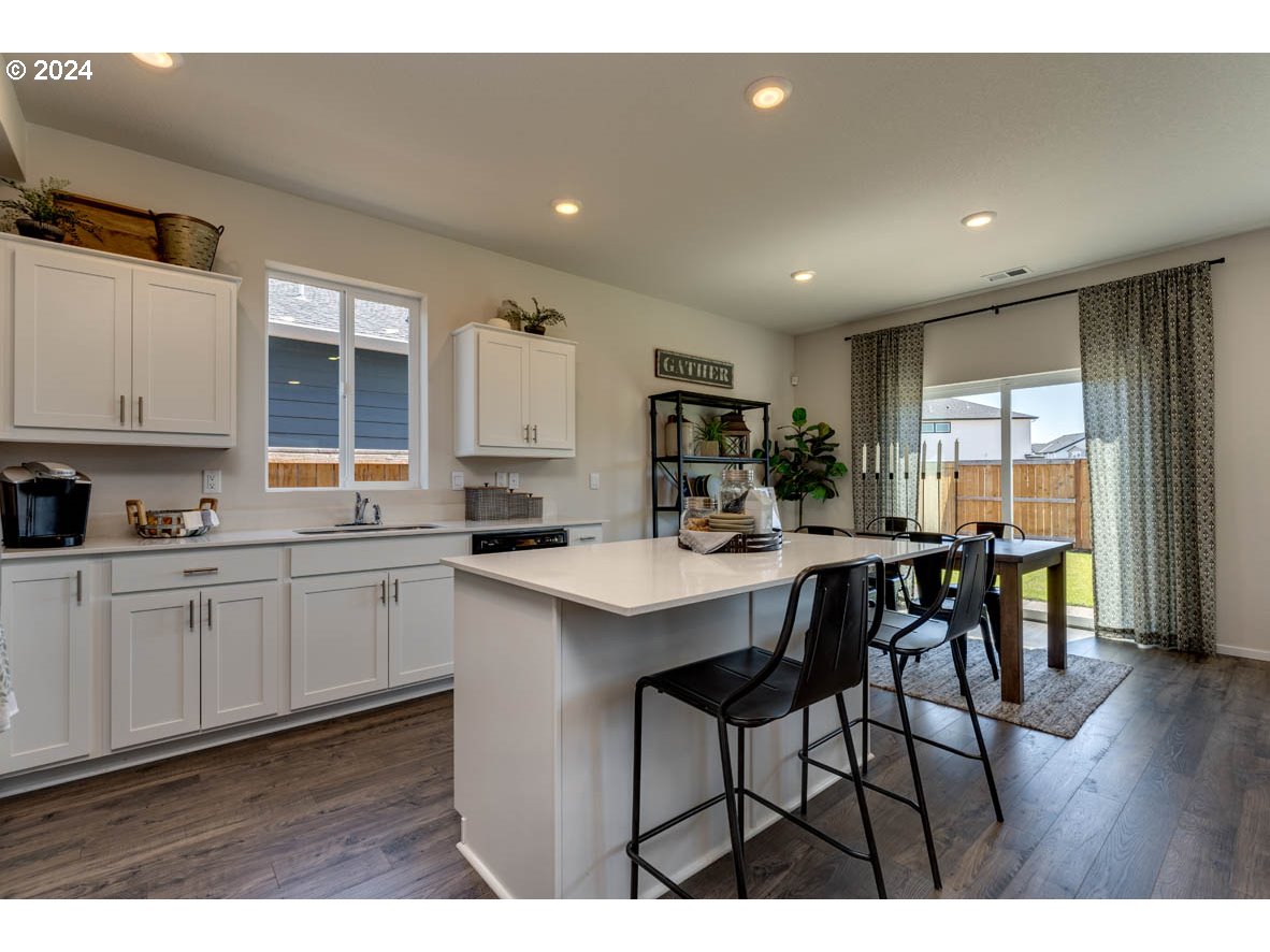2990 U Street Springfield, OR 97477 - Photo 11 of 36 a kitchen with stainless steel appliances kitchen island granite countertop a table chairs sink and cabinets