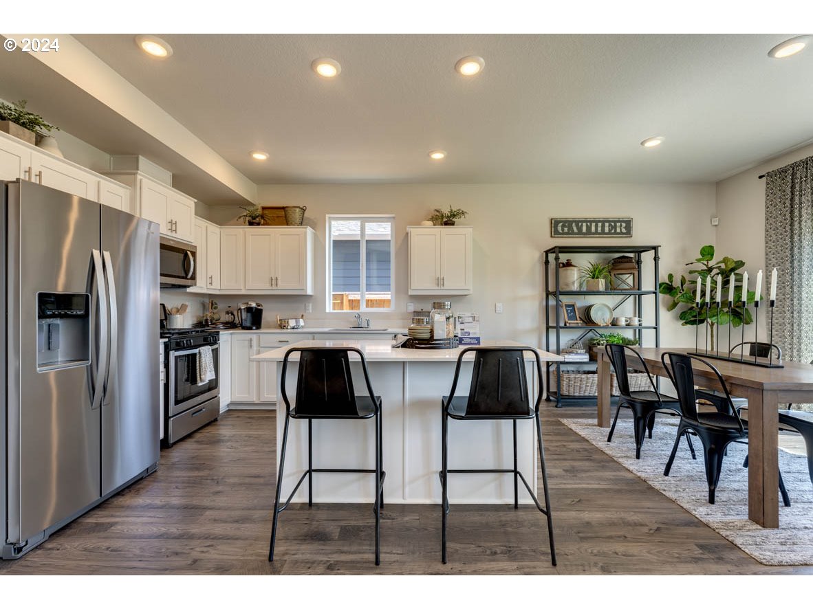 2990 U Street Springfield, OR 97477 - Photo 13 of 36 a kitchen with stainless steel appliances kitchen island granite countertop a refrigerator a stove a dining table and chairs