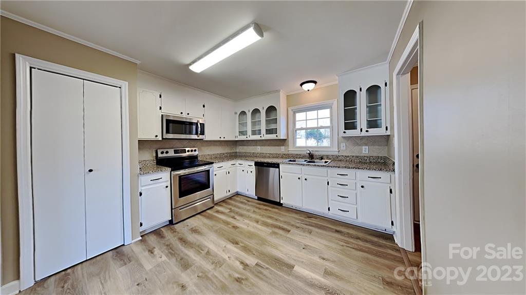 1209 Castlegate Drive Gastonia, NC 28054 - Photo 4 of 13 a kitchen with granite countertop white cabinets and stainless steel appliances