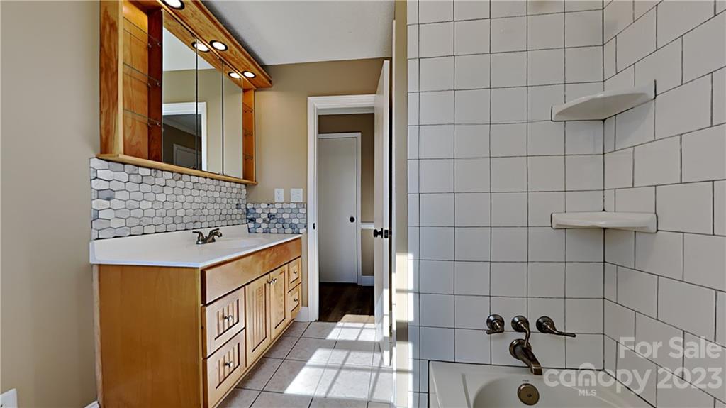 1209 Castlegate Drive Gastonia, NC 28054 - Photo 10 of 13 a bathroom with a sink a mirror and shower
