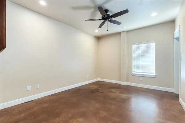 an empty room with a window and a fan