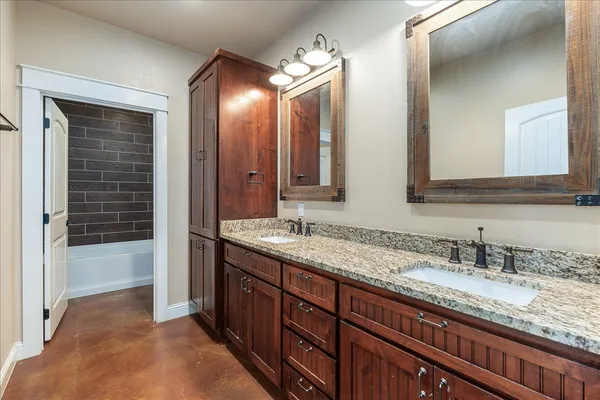 a bathroom with a granite countertop sink double vanity and a mirror
