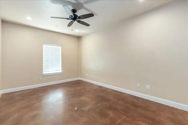 an empty room with a window and a fan