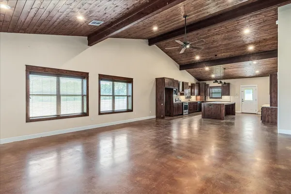 a view of a room with wooden floors and kitchen view