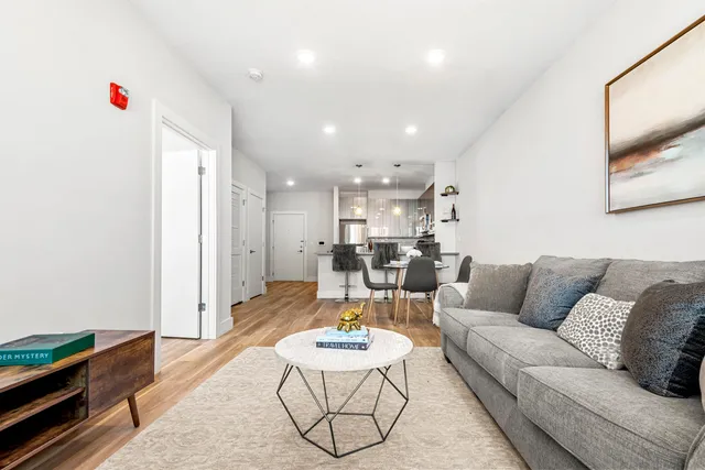 a living room with furniture and a dining table with kitchen view