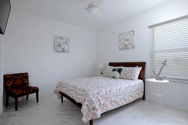 a bedroom with a bed and a lamp on the dresser