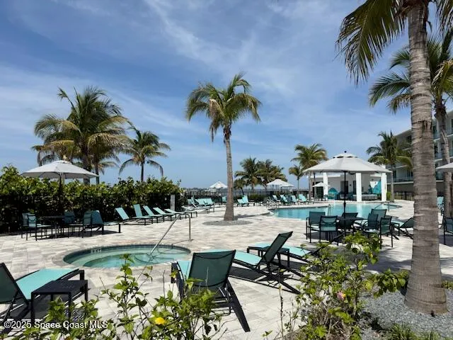 a view of a patio with table and chairs potted plants and palm tree