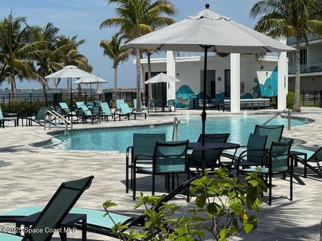 430 Strand Drive Melbourne Beach, FL 32951 - Photo 33 of 36 a view of a patio with table and chairs potted plants and palm tree