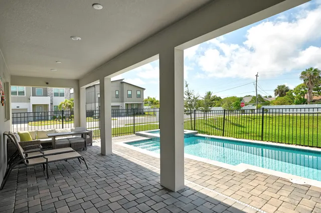 a view of a deck with a floor to ceiling window next to a yard