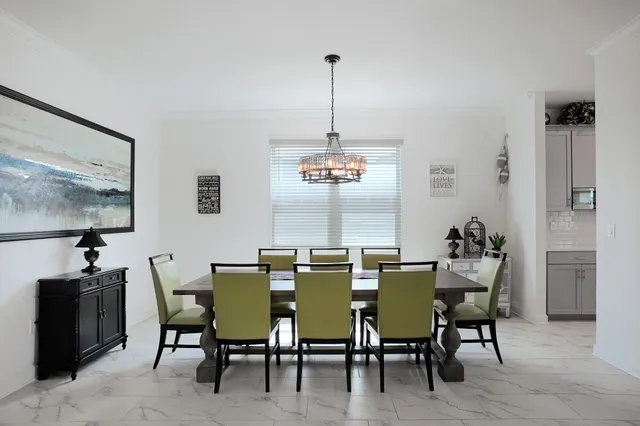 a view of a dining room with furniture a potted plant and wooden floor