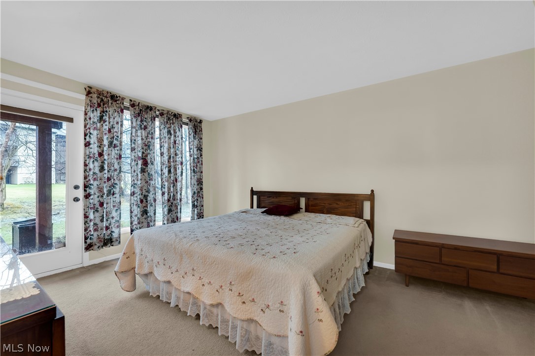 985 Canyon View Road, Unit 108D Northfield, OH 44067 - Photo 12 of 18 Carpeted bedroom featuring access to exterior and baseboards