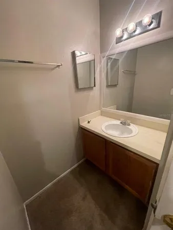 a bathroom with a sink a light fixture and a mirror