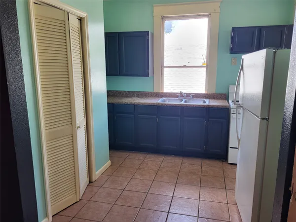 a view of an empty room with wooden floor and a ceiling fan
