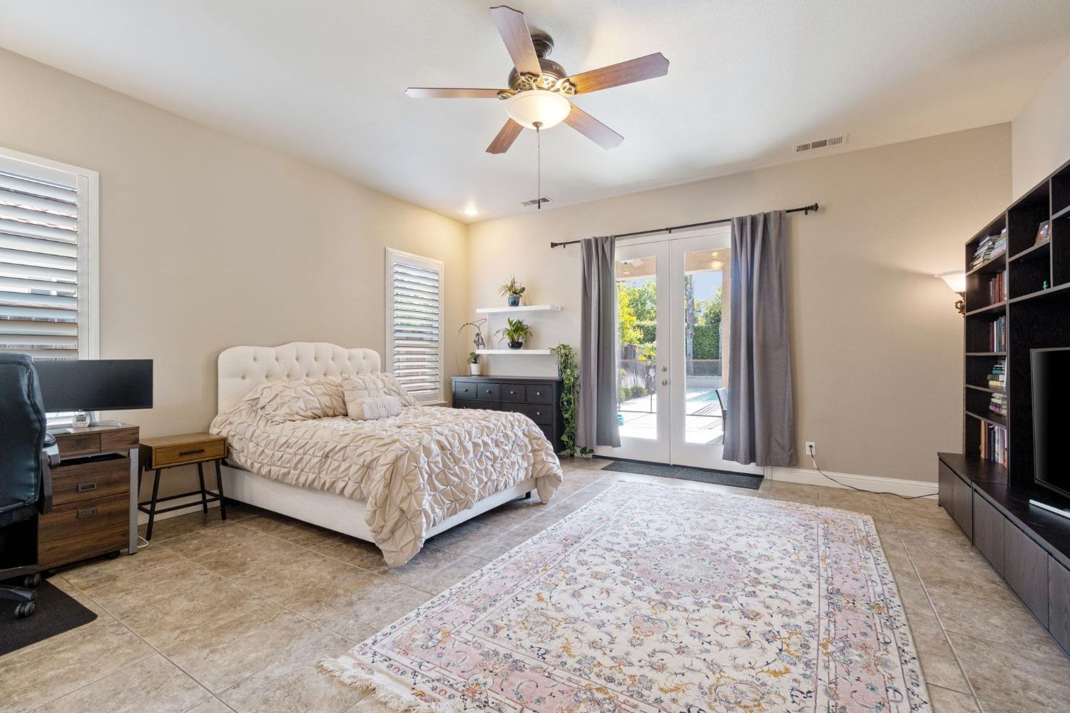 1847 Megan Avenue Clovis, CA 93619 - Photo 20 of 40 a spacious bedroom with a large bed a flat screen tv and a large window