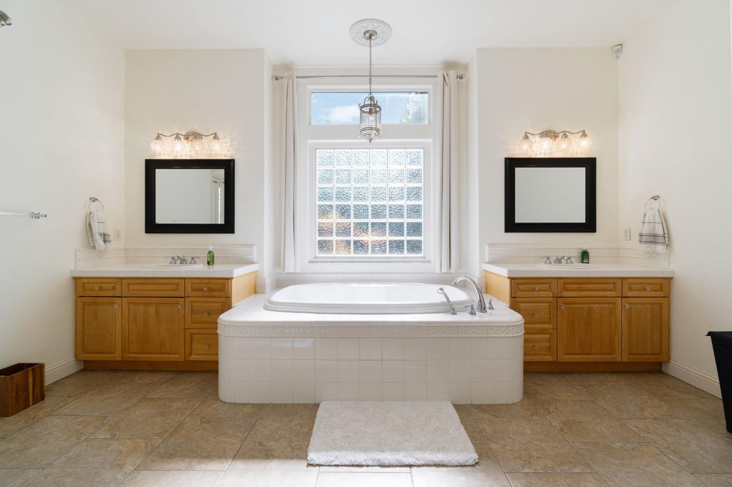 1847 Megan Avenue Clovis, CA 93619 - Photo 32 of 40 a spacious bathroom with a tub double sink window and mirror