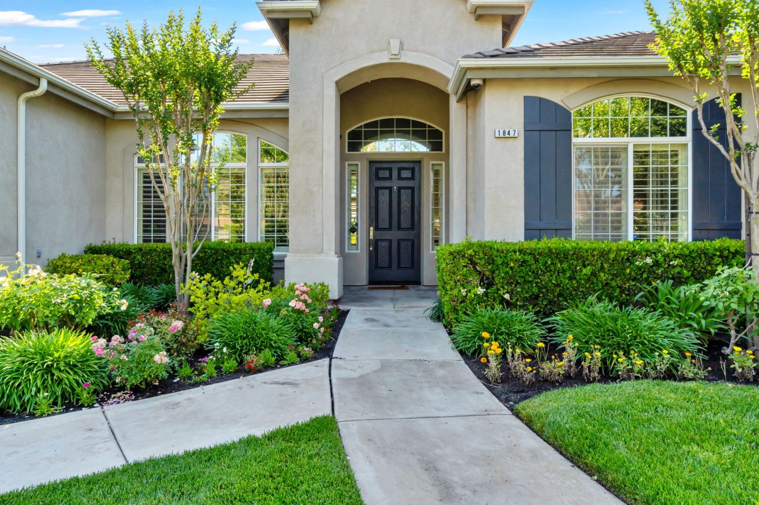 1847 Megan Avenue Clovis, CA 93619 - Photo 4 of 40 a view of a house with brick walls and a flower garden