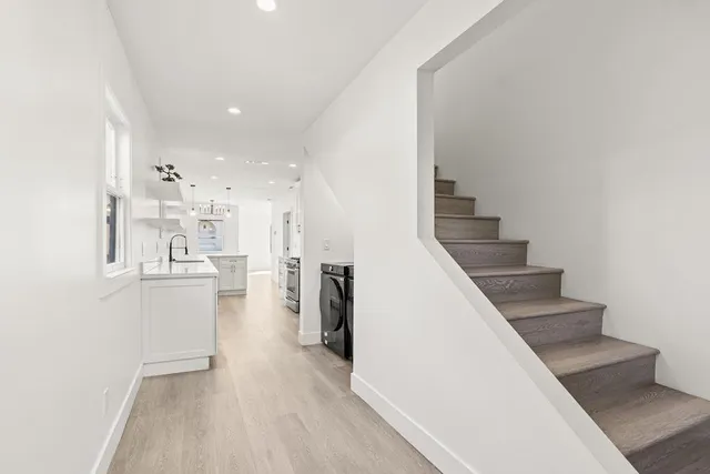 a view of a kitchen with kitchen island wooden floor and electronic appliances