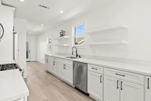 a large white kitchen with a sink
