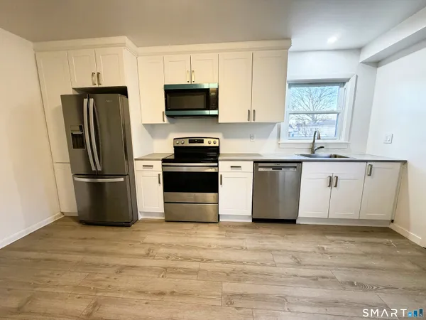 a kitchen with stainless steel appliances granite countertop a stove a refrigerator and a microwave
