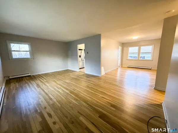 a view of empty room with wooden floor