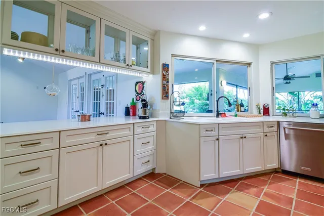 a large white kitchen with a sink and cabinets