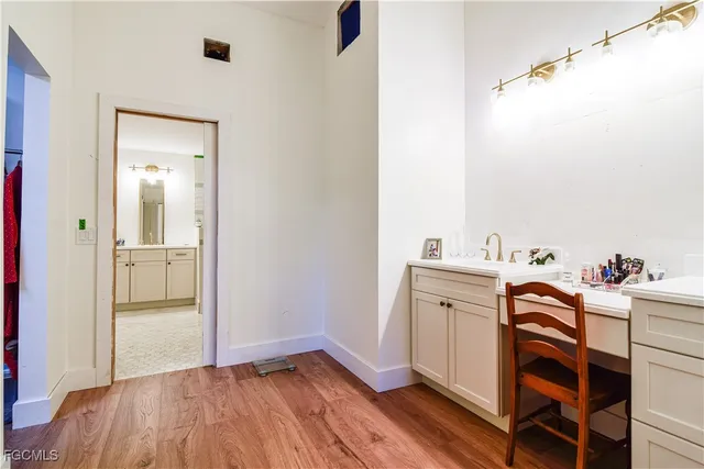 a view of a hallway with wooden floor and closet