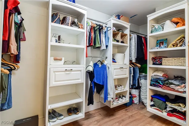 a view of walk in closet with clothes and shoes