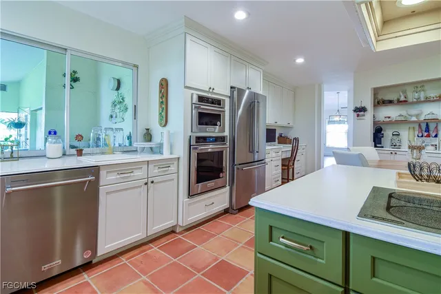 a kitchen with stainless steel appliances a sink cabinets and wooden floor