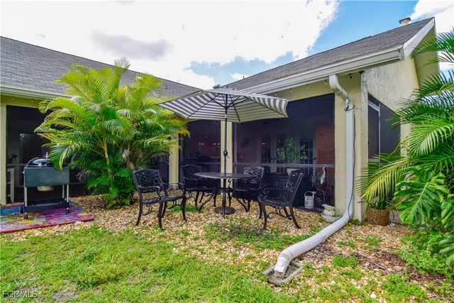 a backyard of a house with table and chairs