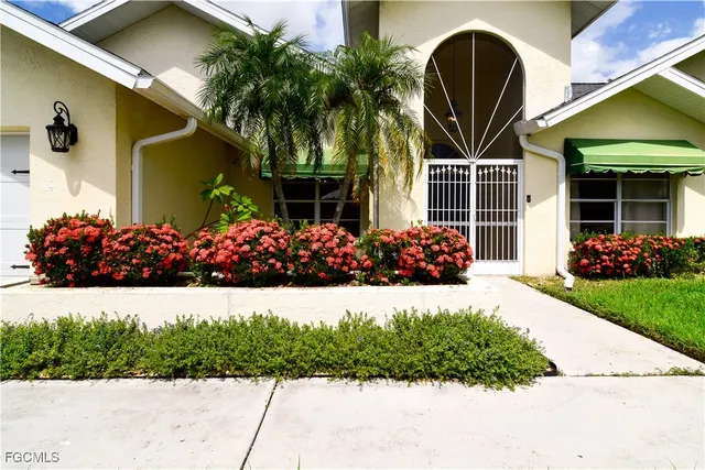 a view of a house with a small yard and potted plants