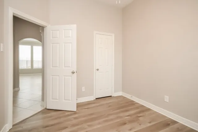 a view of empty room with wooden floor