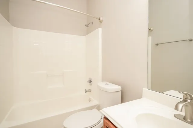 a white toilet sitting next to a bathroom sink and a shower