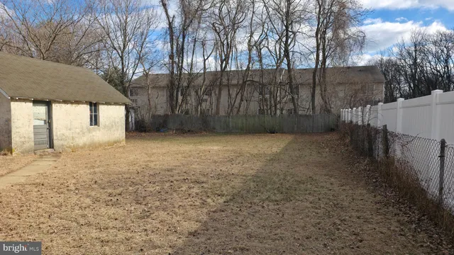 a view of a yard with wooden fence