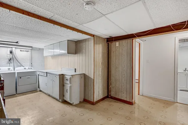 an empty room with wooden floor chandelier fan and windows