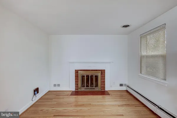 a view of an empty room with a window and a fireplace