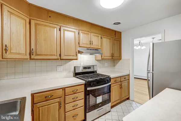 a kitchen with granite countertop a refrigerator stove and cabinets