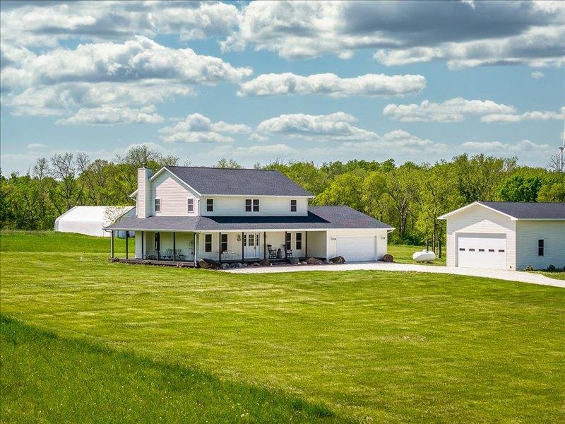 a view of a house with a big yard and large trees