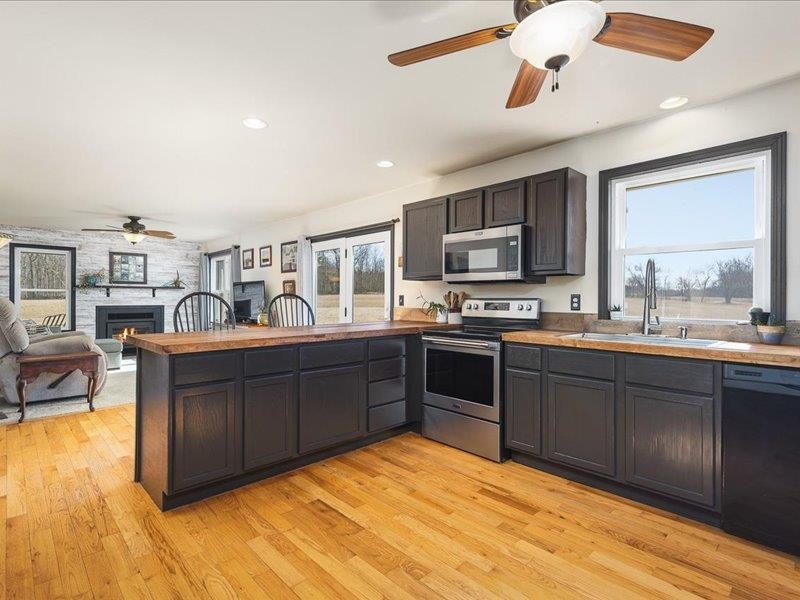 911.41 Melugins Grove Compton, IL 61318 - Photo 20 of 68 a kitchen with stainless steel appliances granite countertop a stove cabinets and living room view