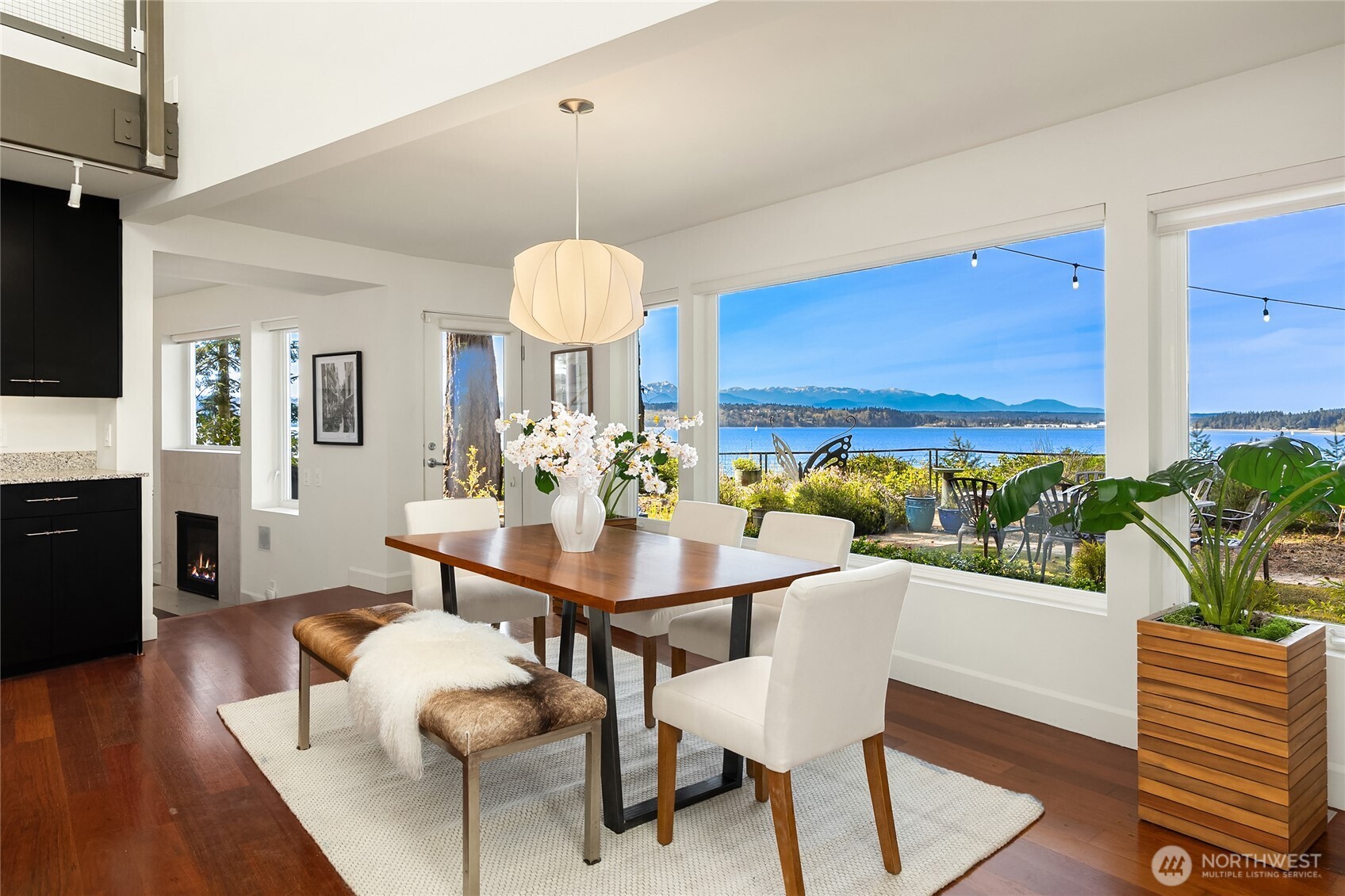 12145 Arrow Point Loop Northeast Bainbridge Island, WA 98110 - Photo 11 of 40 a view of a dining room with furniture a chandelier and wooden floor