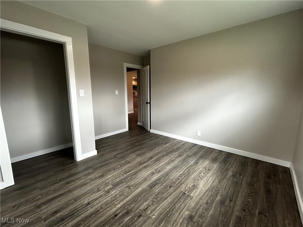 3465 Ridge Road Zanesville, OH 43701 - Photo 11 of 16 Unfurnished bedroom with baseboards and dark wood-type flooring