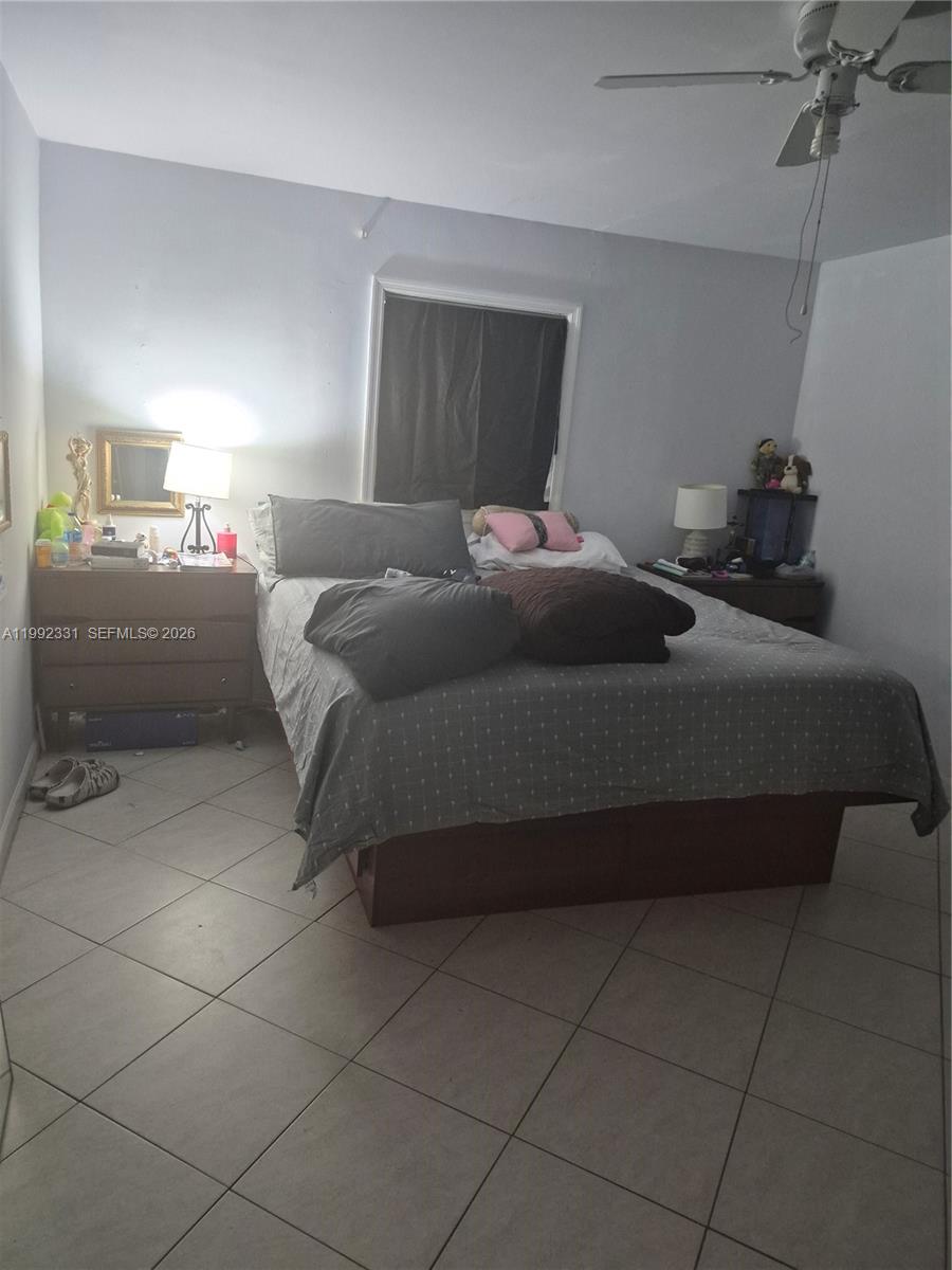 399 Northwest 98th Street Miami, FL 33150 - Photo 3 of 7 a bedroom with a bed and a lamp