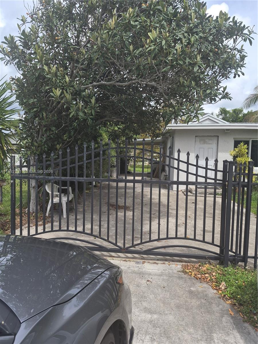 399 Northwest 98th Street Miami, FL 33150 - Photo 7 of 7 a backyard of a house with lawn chairs and wooden fence