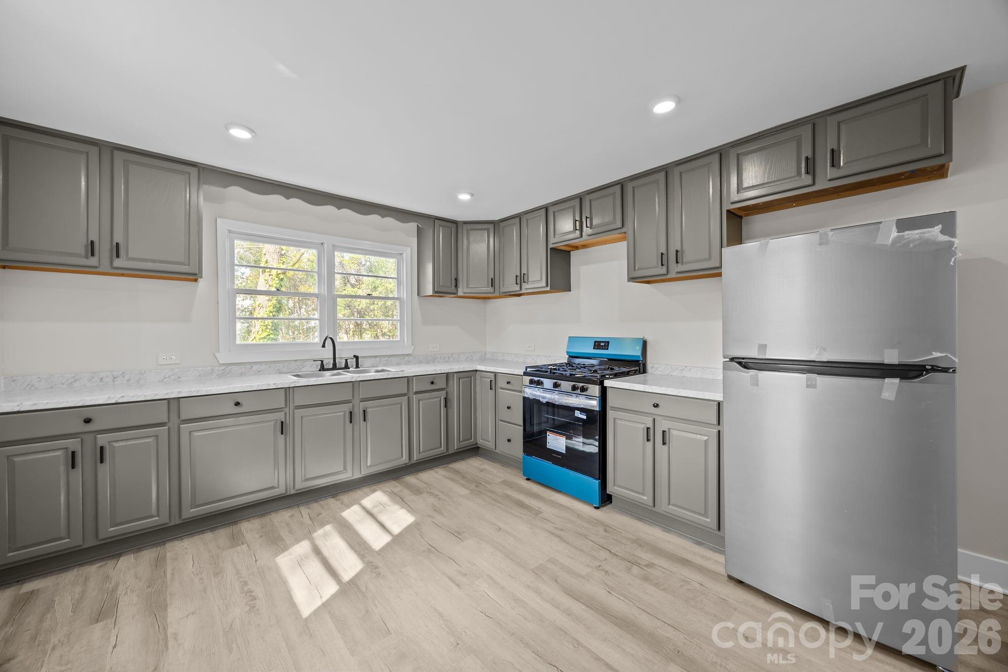511 East Trade Street Dallas, NC 28034 - Photo 9 of 16 a kitchen with granite countertop stainless steel appliances a refrigerator stove top oven and sink